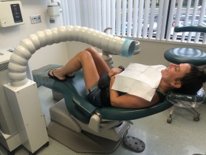Patient sitting in a dental chair with an air purifier